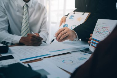 İş ekibi ile yeni başlangıç planı ve tartışma için proje bilgilerini dizüstü bilgisayar ve dijital tablet ile mali strateji bir modern iş salonda çalışıyor.