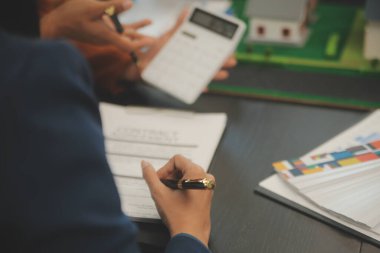 Mimarlar ve iş adamları, emlak yatırımları ve konut geliştirme projesi için zemin planı modifikasyonunu tartışıp fikir alışverişinde bulunuyorlar.