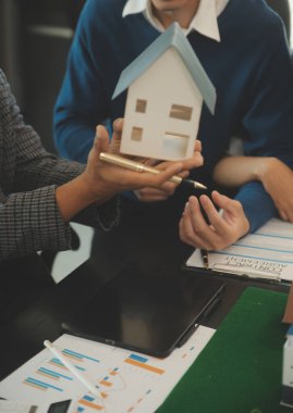 Mimarlar ve iş adamları, emlak yatırımları ve konut geliştirme projesi için zemin planı modifikasyonunu tartışıp fikir alışverişinde bulunuyorlar.