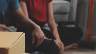 Odada tablet kullanan genç Asyalı adam akıllı telefona odaklanmış.