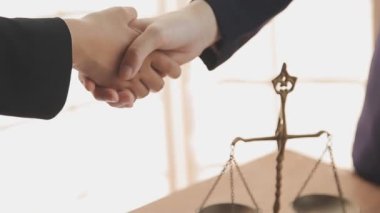 İş adamları, ortak avukatları veya avukatlarıyla anlaşma yapmak için el sıkışıyor.