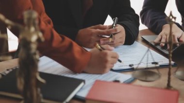 Modern ofiste yeni sözleşme anlaşmasını tartışan bir grup avukat.