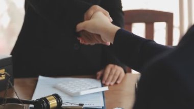 İş adamları, ortak avukatları veya avukatlarıyla anlaşma yapmak için el sıkışıyor.
