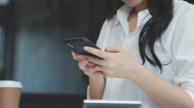 Ofiste akıllı telefon kullanan bir iş kadını.