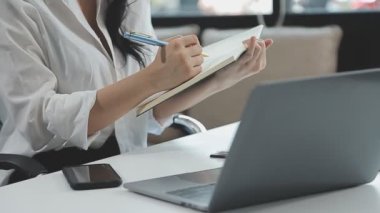 Dizüstü bilgisayar ve defterle çalışan kadın