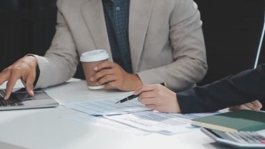 Takım elbiseli genç işadamı elinde bir tablet tutuyor ve ofisten bir meslektaşıyla konuşuyor. İş dünyasındaki takım çalışması kavramı. Kapat - kapat