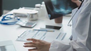 Bilgisayarlı ve tabletli doktor ofiste.