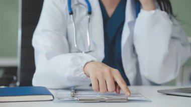 Klinikteki masada oturan genç doktor dizüstü bilgisayarla çalışıyor. Tıbbi konsept. Doktor ofiste bilgisayarla çalışıyor..
