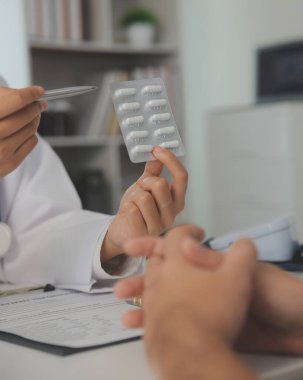 Healthcare service and pharmacy worker with customer at store counter for medication explanation. Pharmaceutical advice and opinion of pharmacist helping girl with medicine information.