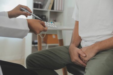 Erkek hastalıkları. Adam ellerini kasıklarına bastırıyor ve acı çekiyor. Panorama, kesilmiş, stüdyo çekimi.