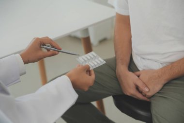 Erkek hastalıkları. Adam ellerini kasıklarına bastırıyor ve acı çekiyor. Panorama, kesilmiş, stüdyo çekimi.