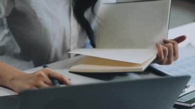Laptop ve belgelerle çalışan genç kadın, yakın plan.