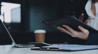 Ofiste elinde siyah kalemle tablet tutan kadın.