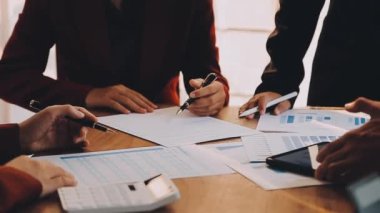 Bir grup iş adamı toplantıda iş belgelerini tartışıyor