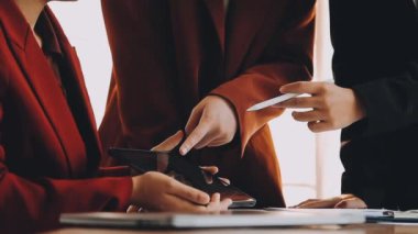 Ofiste otururken cep telefonu kullanan genç iş adamları.