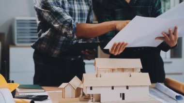 Ofis, inşaat ve mühendislik projesinin planları ve planlarıyla çalışan mimar mühendis ve mühendis