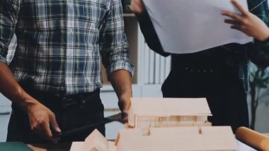 Genç mimar ofiste planlarla çalışıyor.