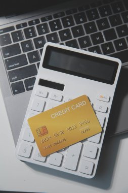 Koyu arkaplan, plastik kartlar ve banknotlar üzerindeki hesap makinesi