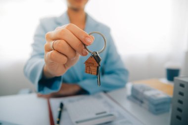 Emlakçı ev satın alma anlaşmasının şartları hakkında konuştu ve müşteriden sözleşmeyi yasal hale getirmek için belgeleri imzalamasını istedi, ev satışları ve ev sigortası kavramı.