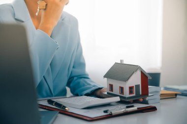 Emlakçı ev satın alma anlaşmasının şartları hakkında konuştu ve müşteriden sözleşmeyi yasal hale getirmek için belgeleri imzalamasını istedi, ev satışları ve ev sigortası kavramı.