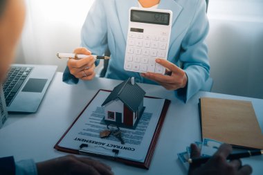 Emlakçı ev satın alma anlaşmasının şartları hakkında konuştu ve müşteriden sözleşmeyi yasal hale getirmek için belgeleri imzalamasını istedi, ev satışları ve ev sigortası kavramı.