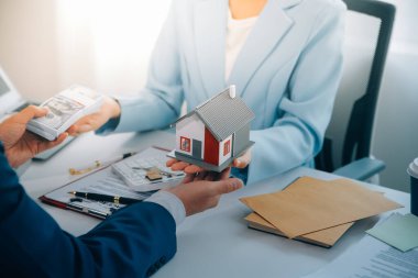 Emlakçı ev satın alma anlaşmasının şartları hakkında konuştu ve müşteriden sözleşmeyi yasal hale getirmek için belgeleri imzalamasını istedi, ev satışları ve ev sigortası kavramı.