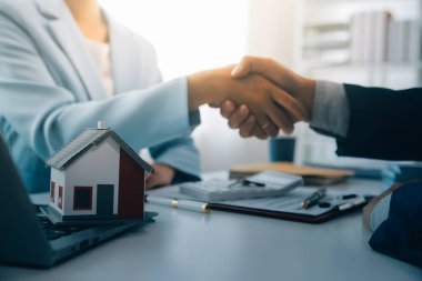 Emlakçı ev satın alma anlaşmasının şartları hakkında konuştu ve müşteriden sözleşmeyi yasal hale getirmek için belgeleri imzalamasını istedi, ev satışları ve ev sigortası kavramı.