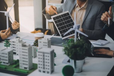 Yeşil Enerji Şirketi, güneş pili ve rüzgar türbini jeneratörü ile sürdürülebilir ve yenilenebilir temiz enerji ürünlerinin pazarlanmasını planlayan ve görüşen iş adamlarıyla görüşüyor. Önde.