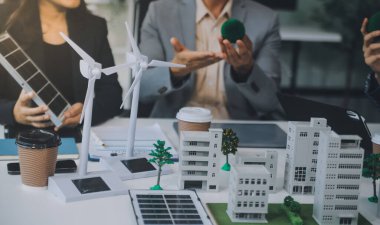 Yeşil Enerji Şirketi, güneş pili ve rüzgar türbini jeneratörü ile sürdürülebilir ve yenilenebilir temiz enerji ürünlerinin pazarlanmasını planlayan ve görüşen iş adamlarıyla görüşüyor. Önde.
