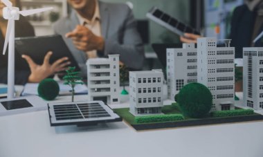 Yeşil Enerji Şirketi, güneş pili ve rüzgar türbini jeneratörü ile sürdürülebilir ve yenilenebilir temiz enerji ürünlerinin pazarlanmasını planlayan ve görüşen iş adamlarıyla görüşüyor. Önde.