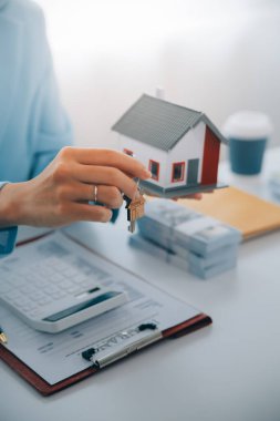 Emlakçı ev satın alma anlaşmasının şartları hakkında konuştu ve müşteriden sözleşmeyi yasal hale getirmek için belgeleri imzalamasını istedi, ev satışları ve ev sigortası kavramı.