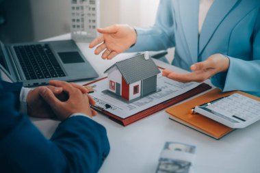 Emlakçı ev satın alma anlaşmasının şartları hakkında konuştu ve müşteriden sözleşmeyi yasal hale getirmek için belgeleri imzalamasını istedi, ev satışları ve ev sigortası kavramı.