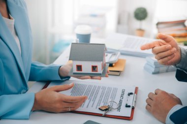 Emlakçı ev satın alma anlaşmasının şartları hakkında konuştu ve müşteriden sözleşmeyi yasal hale getirmek için belgeleri imzalamasını istedi, ev satışları ve ev sigortası kavramı.