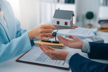 Emlakçı ev satın alma anlaşmasının şartları hakkında konuştu ve müşteriden sözleşmeyi yasal hale getirmek için belgeleri imzalamasını istedi, ev satışları ve ev sigortası kavramı.