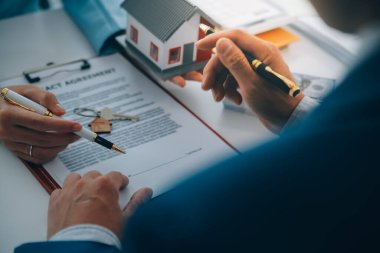 Emlakçı ev satın alma anlaşmasının şartları hakkında konuştu ve müşteriden sözleşmeyi yasal hale getirmek için belgeleri imzalamasını istedi, ev satışları ve ev sigortası kavramı.