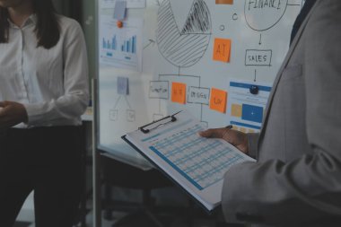 Finansal analistler, şirketlerin başarılı takım çalışmalarının sonuçlarını gösteren bir toplantıda bir dijital tablet planlama yatırım projesinin ticari mali raporlarını analiz ediyorlar..