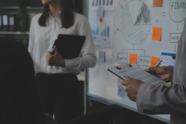 Finansal analistler, şirketlerin başarılı takım çalışmalarının sonuçlarını gösteren bir toplantıda bir dijital tablet planlama yatırım projesinin ticari mali raporlarını analiz ediyorlar..