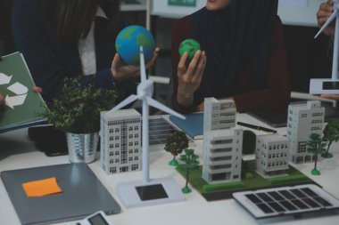 İş adamlarının şirket ofisinde rüzgar enerjisi hakkında görüşleri var. İş ekibi yel değirmeni ve alternatif yeşil enerji hakkında konuşuyor. Modern ofiste yönetici toplantısı.