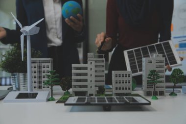 İş adamlarının şirket ofisinde rüzgar enerjisi hakkında görüşleri var. İş ekibi yel değirmeni ve alternatif yeşil enerji hakkında konuşuyor. Modern ofiste yönetici toplantısı.