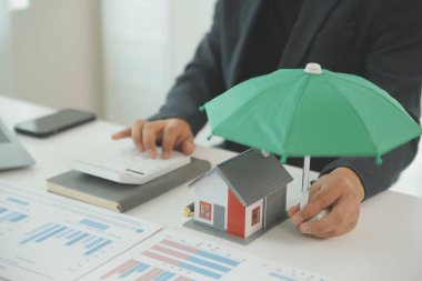 Businessmen holding pens, signing home titles with insurance, care about real estate services and the idea of real estate agents offering interest in installments to their customers.