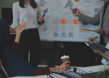 Finansal analistler, şirketlerin başarılı takım çalışmalarının sonuçlarını gösteren bir toplantıda bir dijital tablet planlama yatırım projesinin ticari mali raporlarını analiz ediyorlar..