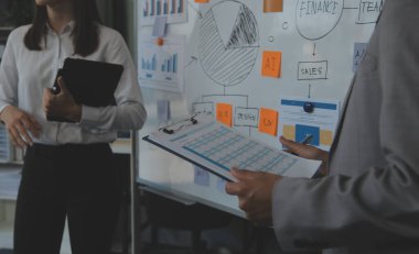 Finansal analistler, şirketlerin başarılı takım çalışmalarının sonuçlarını gösteren bir toplantıda bir dijital tablet planlama yatırım projesinin ticari mali raporlarını analiz ediyorlar..