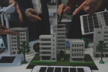 İş adamlarının şirket ofisinde rüzgar enerjisi hakkında görüşleri var. İş ekibi yel değirmeni ve alternatif yeşil enerji hakkında konuşuyor. Modern ofiste yönetici toplantısı.