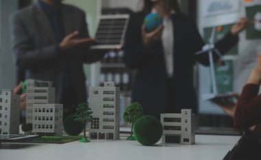 İş adamlarının şirket ofisinde rüzgar enerjisi hakkında görüşleri var. İş ekibi yel değirmeni ve alternatif yeşil enerji hakkında konuşuyor. Modern ofiste yönetici toplantısı.