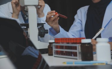 Sağlık personeli sabah toplantı odasında toplanıyor. Dijital tablete bakan doktorlar ve hemşireler.