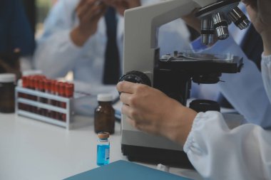 Sağlık personeli sabah toplantı odasında toplanıyor. Dijital tablete bakan doktorlar ve hemşireler.