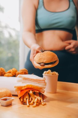 Yemek ya da değil. Burger bakarak cheerless tombul kadın yemek ya da değil düşünme