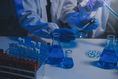 Kimyager ve bilim adamı test tüpüne kimyasal sıvı bırakıyor. Bilim araştırma ve geliştirme konsepti.