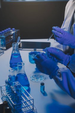 Kimyager ve bilim adamı test tüpüne kimyasal sıvı bırakıyor. Bilim araştırma ve geliştirme konsepti.