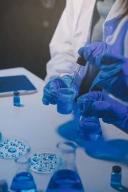 Kimyager ve bilim adamı test tüpüne kimyasal sıvı bırakıyor. Bilim araştırma ve geliştirme konsepti.